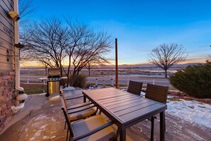 Enjoy a meal al fresco with a view of the distant landscape from this patio, featuring a barbecue grill and comfortable seating.