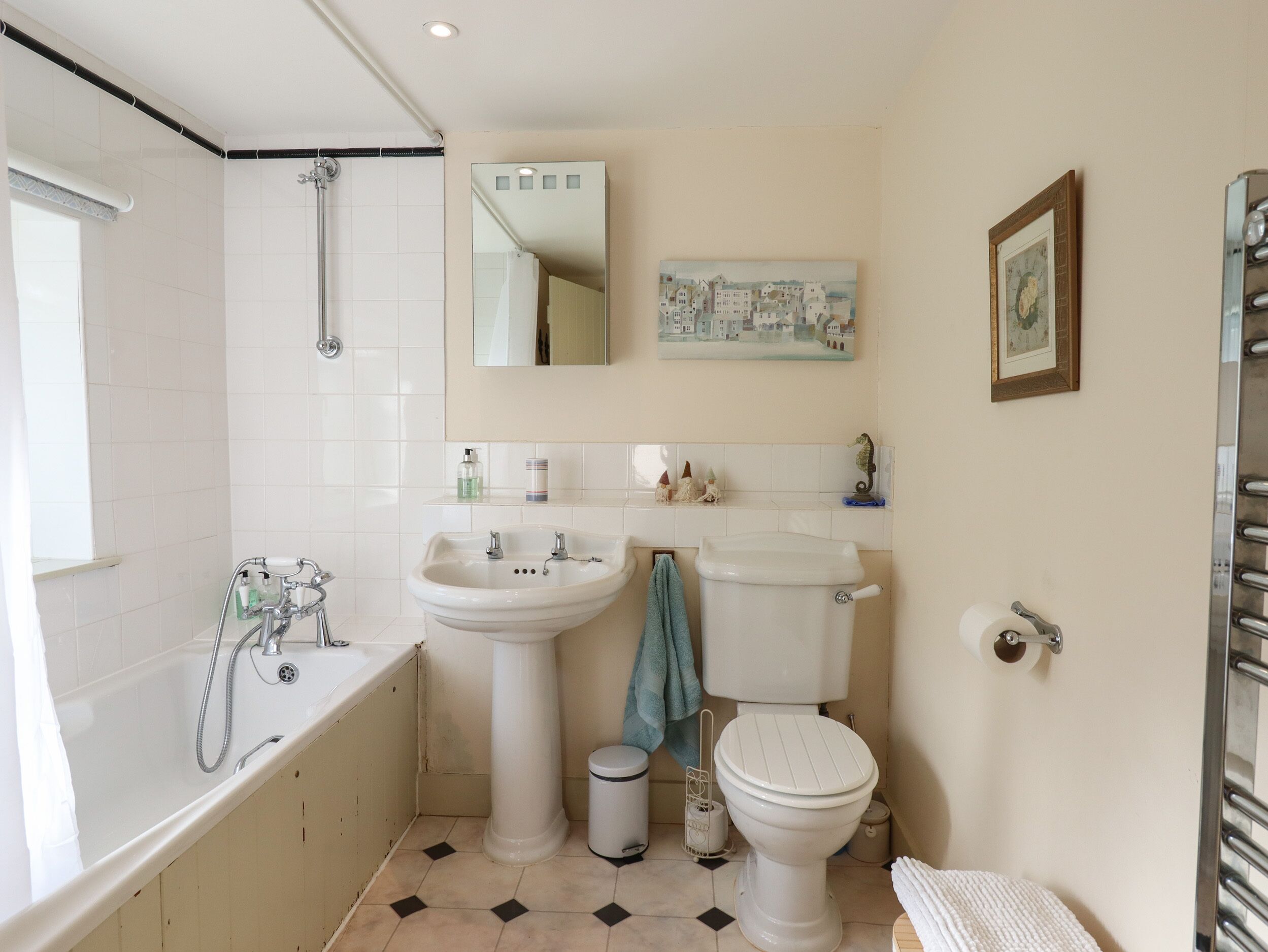 Un baño con bañera, lavabo, inodoro y espejo.