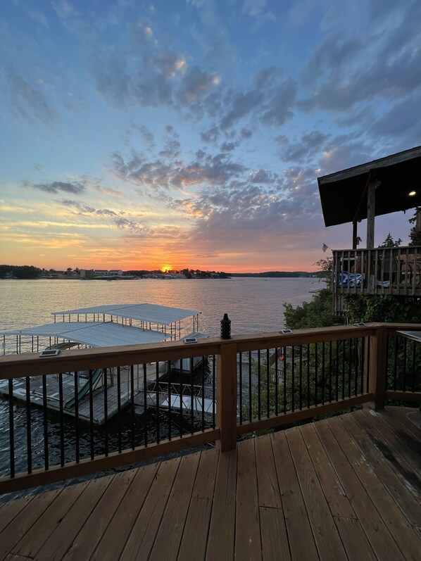 Relax on the deck overlooking the water with a table and chair for a peaceful retreat.