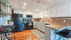 Enjoy cooking in this well-equipped kitchen with an oven, microwave, and sink, plus ample storage and a comfortable workspace.