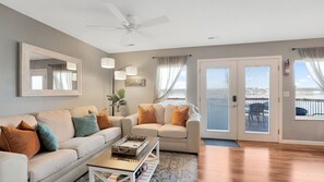 Relax in this inviting living room with a sofa set, coffee table, and floor lamp, offering a comfortable space to unwind.