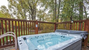 Un bain à remous doté d’une terrasse en bois et d’un panneau indiquant qu’il faut remettre le couvercle une fois l’utilisation terminée.
