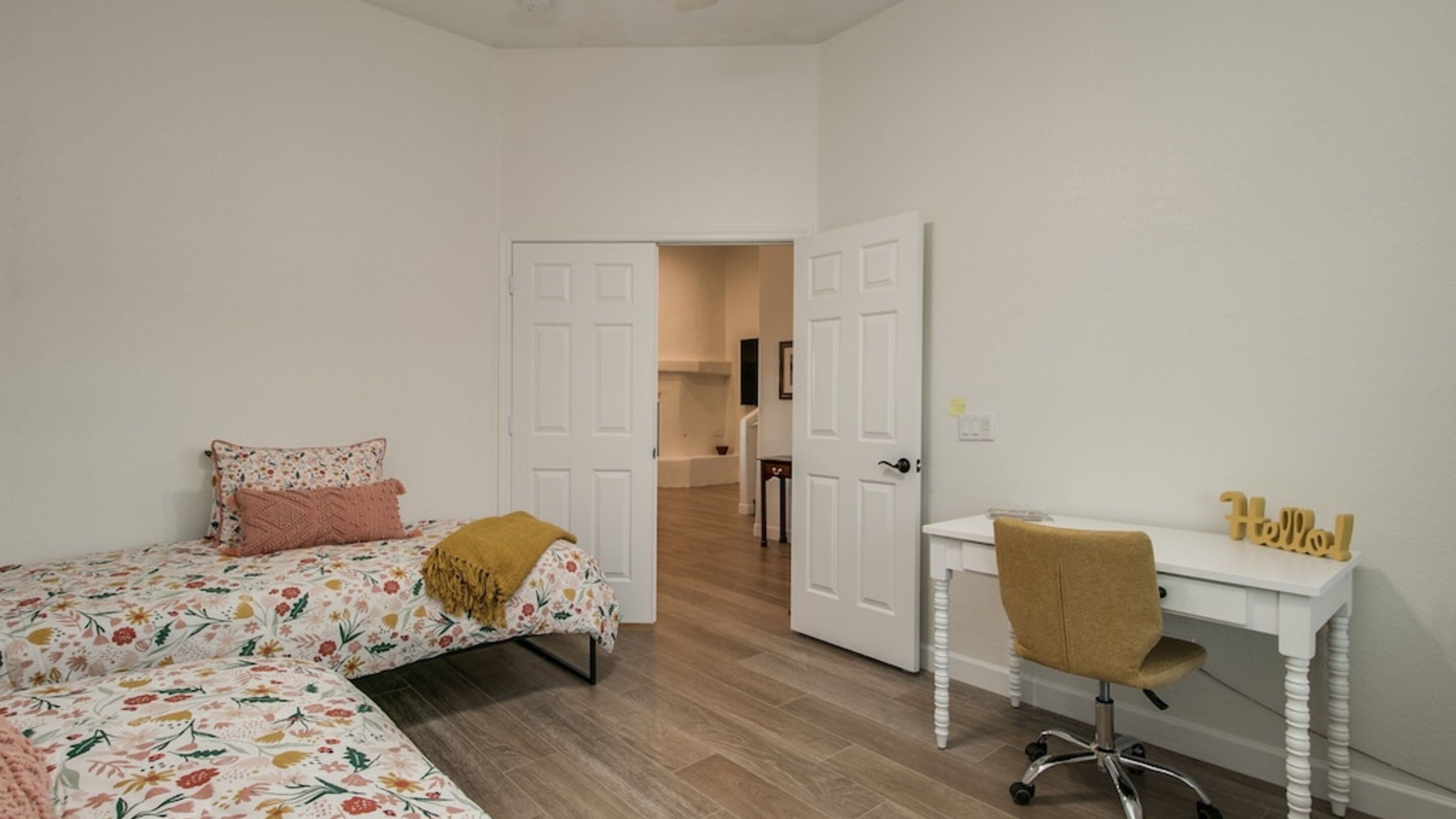 Un dormitorio con una cama, un escritorio y una silla.