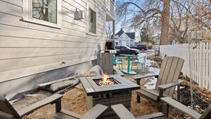 A backyard with a fire pit, outdoor seating, and a house in the background. - Cozy Home in Downtown Loveland W/ Free Bikes! (Loveland)