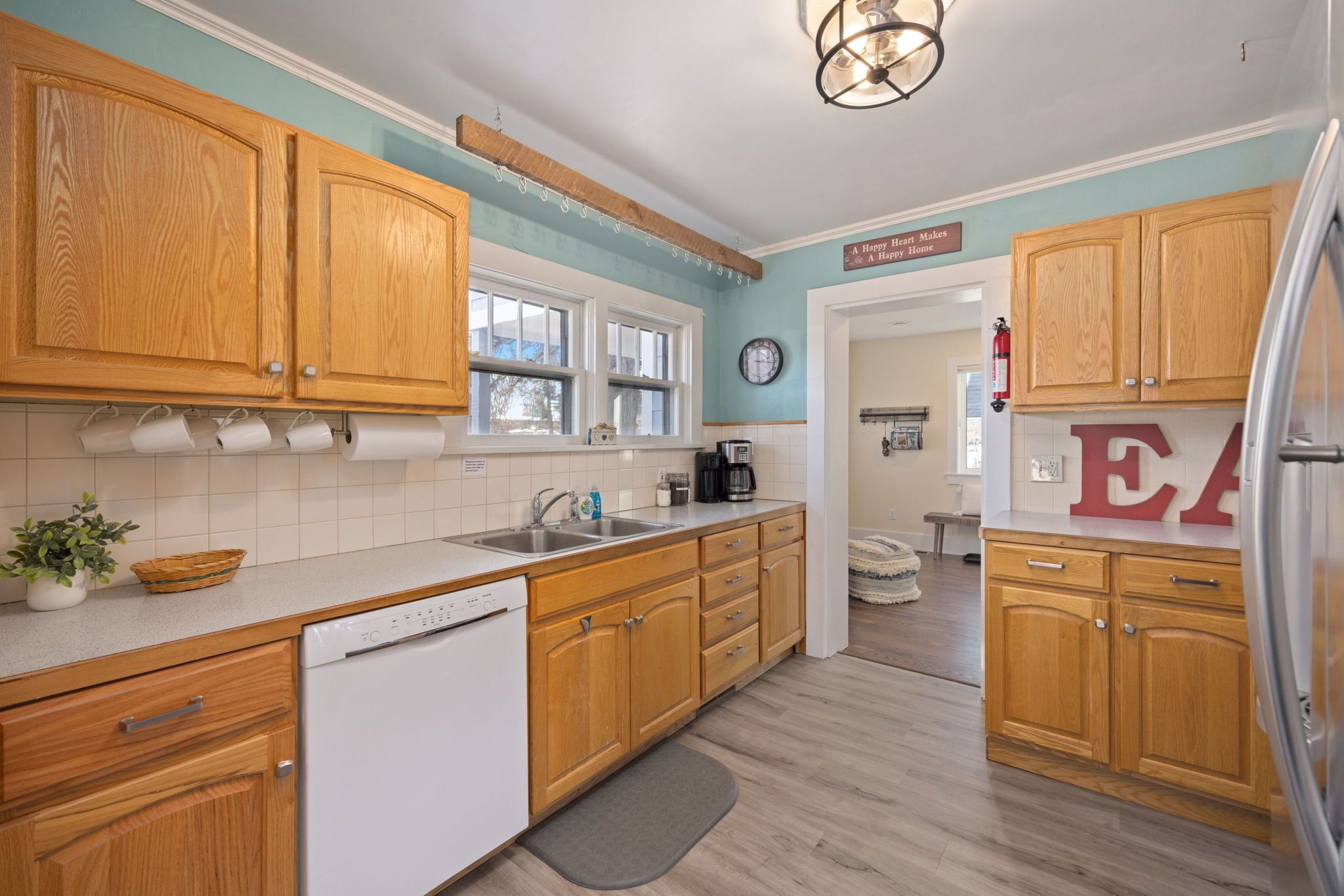 A kitchen with wooden cabinets, a dishwasher, a sink, and a coffee maker.