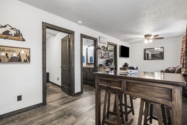 A modern kitchen with wooden flooring, a bar area, and a dining table.