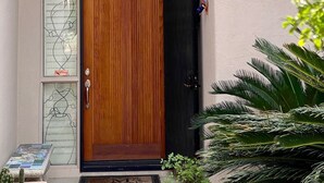 A wooden door with a glass panel and a small window above it.
