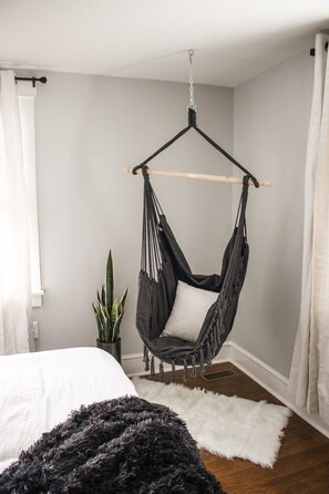 A room with a bed, a hanging chair, a white rug, and a potted plant. - ❤Beautifully Renovated Lancaster Apt❤ (Lancaster)