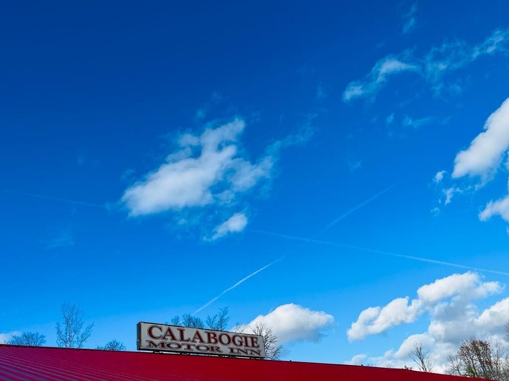 A motel sign with the name "Calabogie Motor Inn" against a clear blue sky with some clouds.