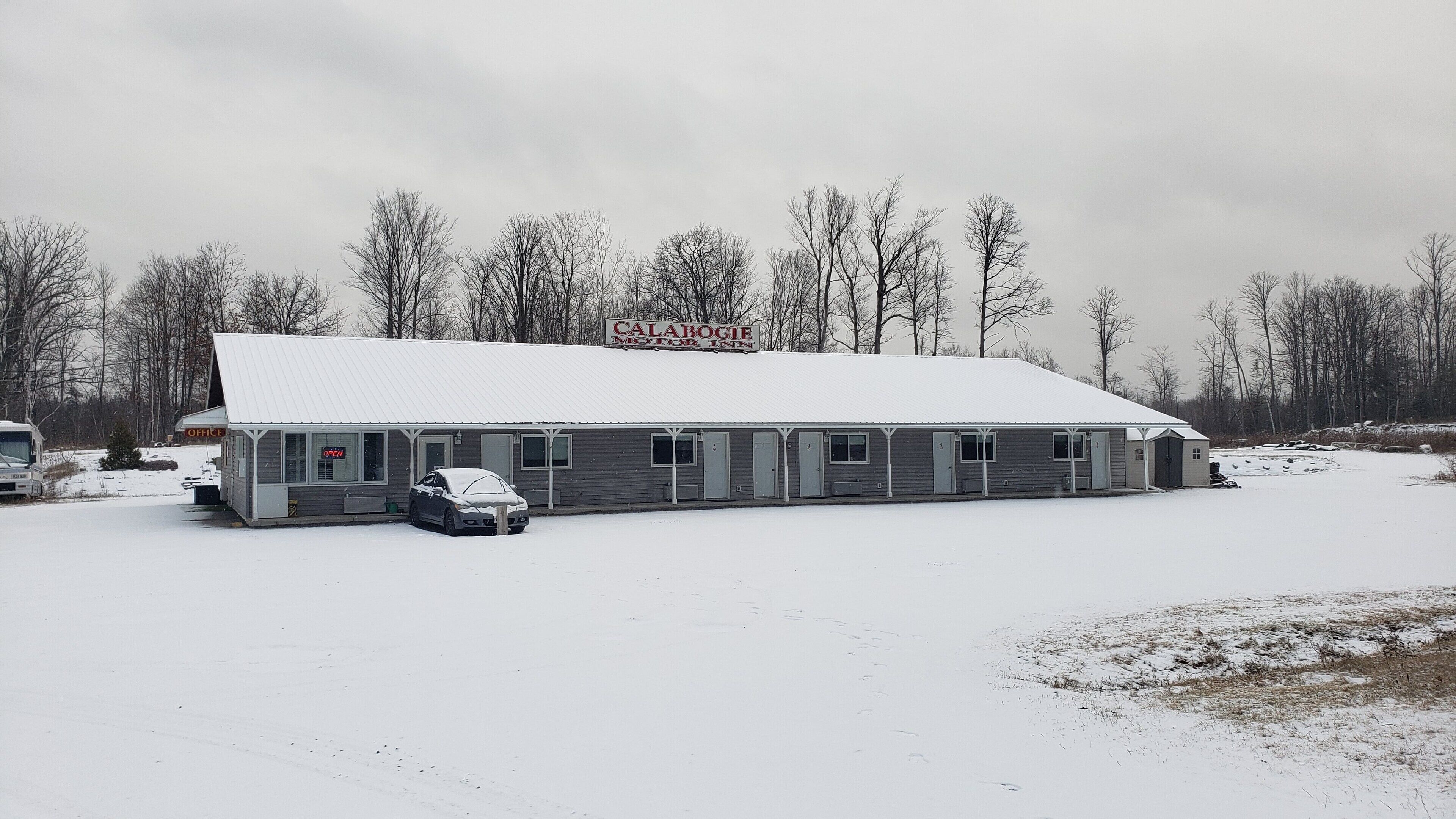 Ett motell med en skylt som visar texten ”Calabogie Motor Inn” och ett takförsett parkeringsområde.