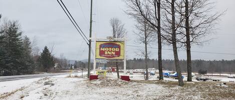 Une enseigne indiquant la présence d’un motel, avec un message accueillant.