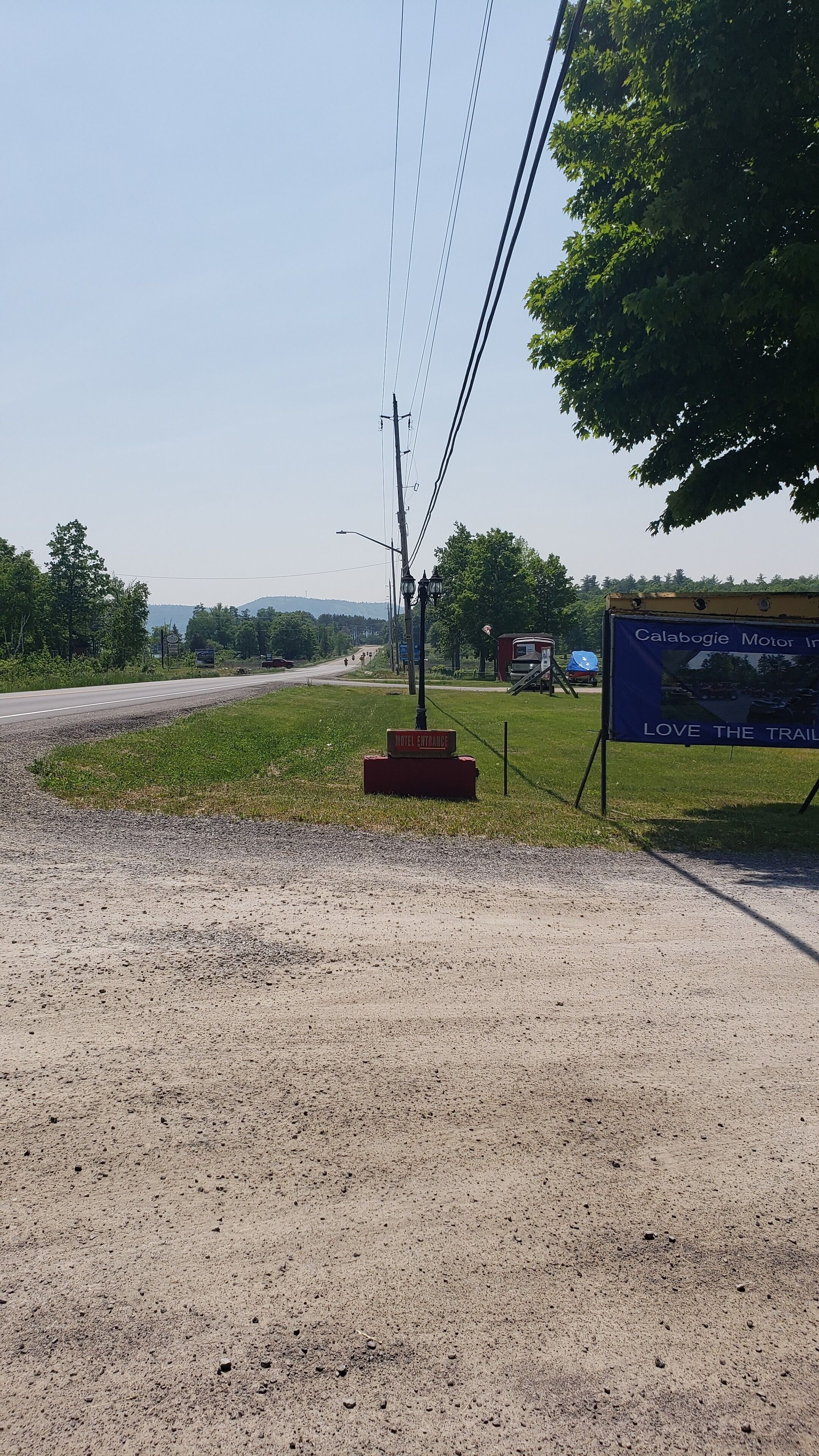 A gravel road with a sign indicating a hotel entrance.