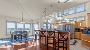 A spacious kitchen with wooden cabinets, a large island, and a view of the ocean. - Soundfront, Pool, Hot Tub, Elevator, Private Dock, Boat Ramp, & Game Room (Salvo)
