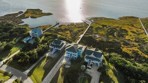 An aerial view of a coastal property with multiple buildings, a dock, and a clear view of the ocean. - Soundfront, Pool, Hot Tub, Elevator, Private Dock, Boat Ramp, & Game Room (Salvo)
