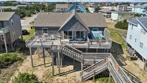 A beachfront property with a large house, a swimming pool, and a wooden deck. - Beachfront, Oceanviews, Dog Friendly, Private Beach Access & Hot Tub (Avon)