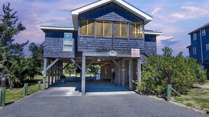 A two-story building with a covered entrance and a sign indicating a shop. - Dogs Welcome, 25 Yards to Beach Access, Private Pool & Hot Tub (Avon)