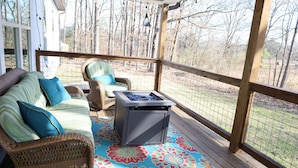 A covered porch with a wicker sofa, a chair, and a small table. - Modern Family-sized Country Gem near Chattanooga with relaxing balcony & deck! (Ringgold)