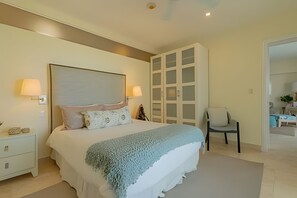 Relax in this serene bedroom with a large bed, bedside lamps, and a stylish nightstand.