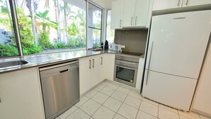 Eine moderne Küche mit Geschirrspüler, Backofen und Kühlschrank.