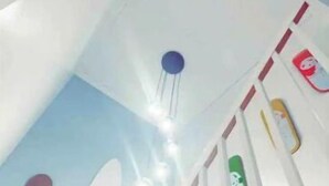 Una escalera con barandilla blanca y pared azul con diseño de olas.