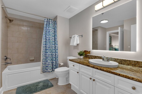 A bathroom with a bathtub, toilet, and sink.