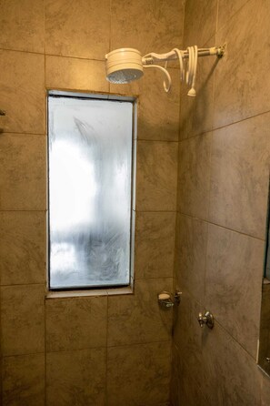 Enjoy a refreshing shower experience with a wall-mounted showerhead and safety handrail.