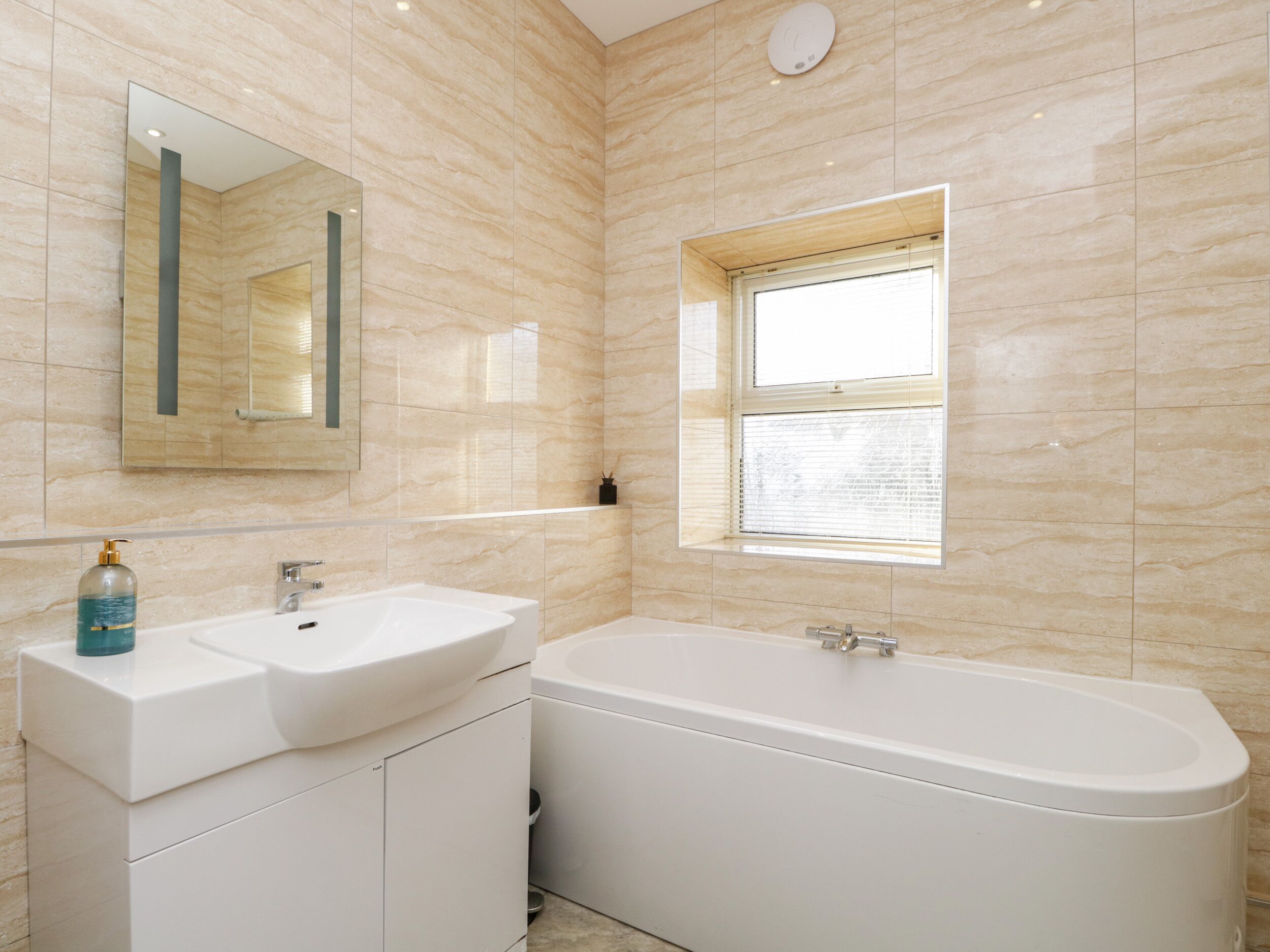 Une salle de bain moderne avec deux lavabos, une baignoire et une fenêtre.