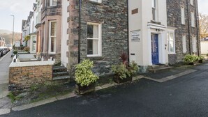 A two-story stone building with a blue door and a sign indicating it is a private property.