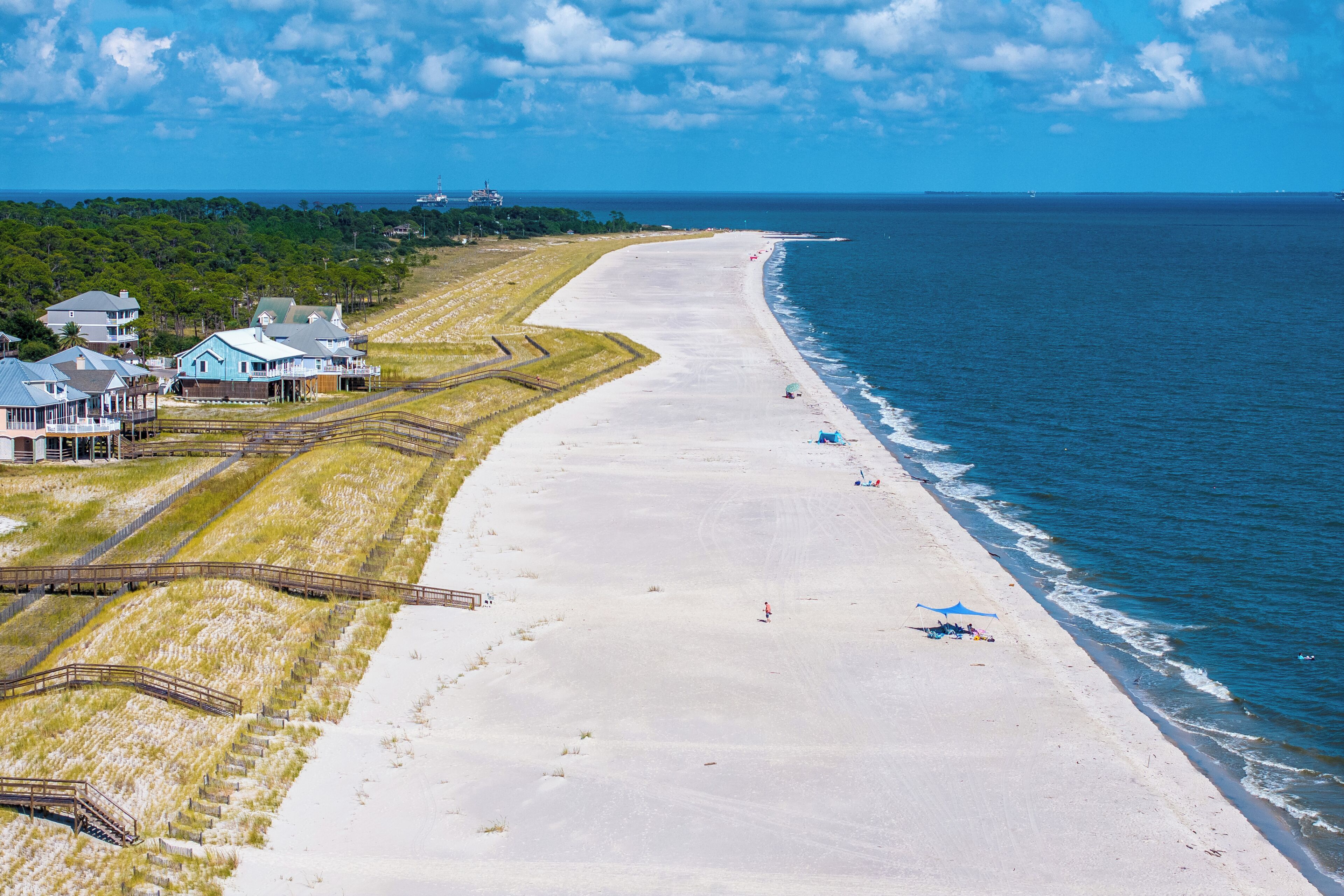 Une propriété située sur la côte, dotée d’une plage, d’une jetée et d’une grande maison à plusieurs niveaux.