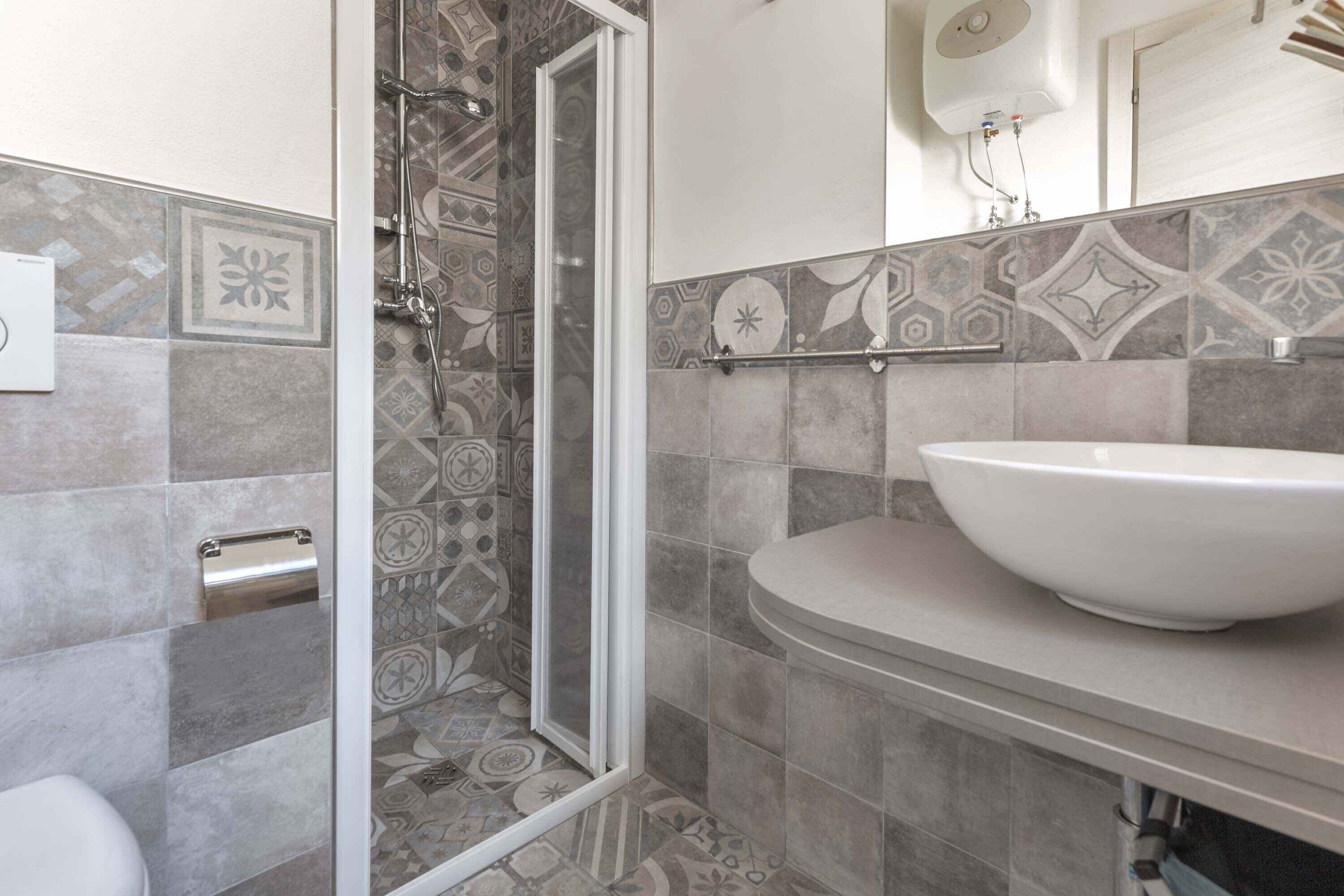 A bathroom with a shower, toilet, and sink.