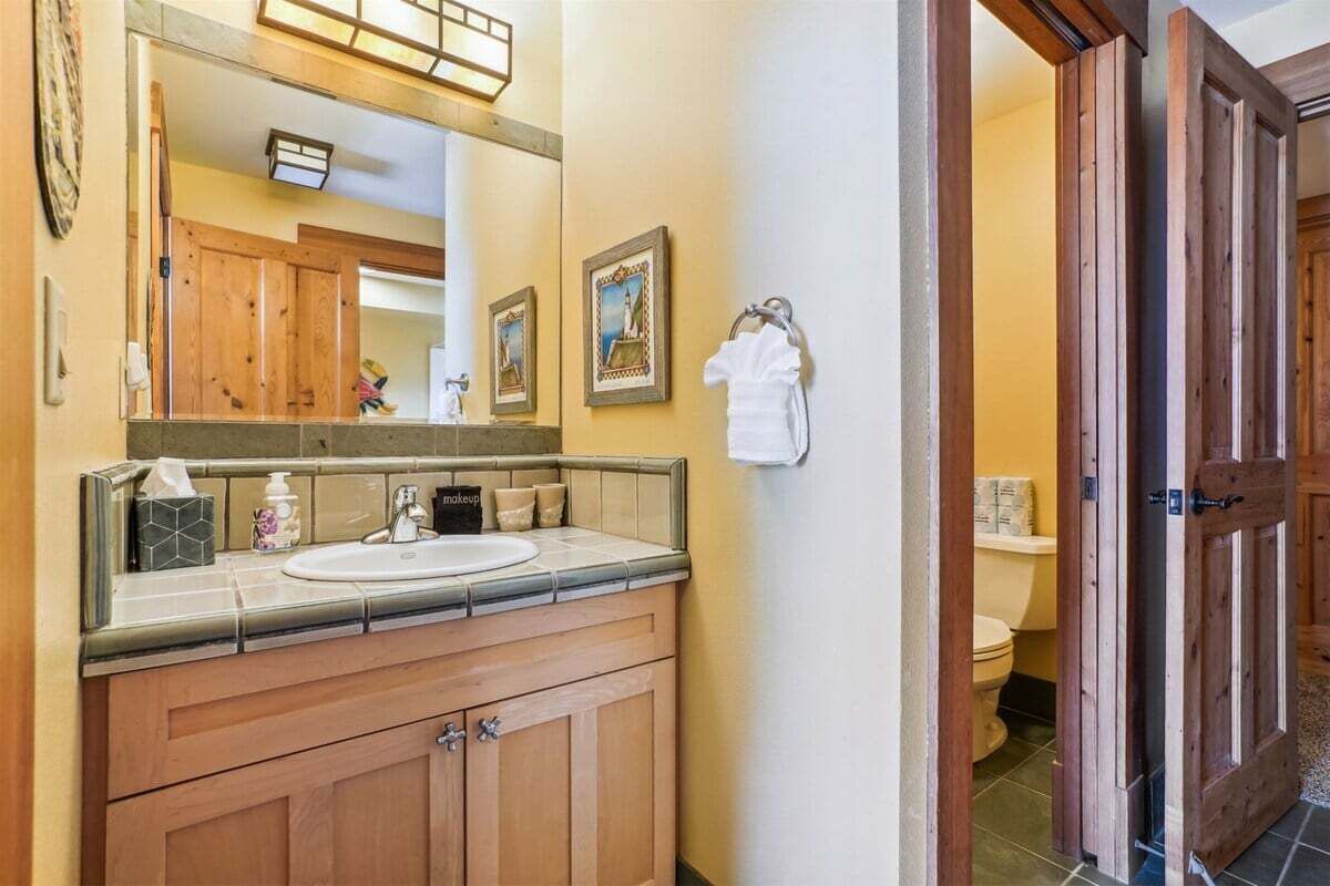 Ein Badezimmer mit Holzausstattung, einem Waschbecken und einer Toilette.