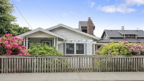 A two-story house with a covered porch, a brick chimney, and a wooden fence. - Sisters - 1 Block to the Beach! (Cannon Beach)