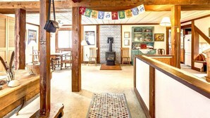 Un intérieur rustique avec des poutres apparentes, une cheminée et un coin repas.