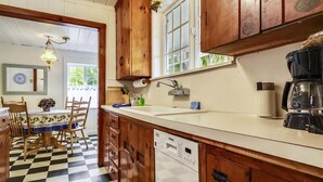 A kitchen with wooden cabinets, a dishwasher, and a coffee maker.