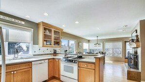 A kitchen with wooden cabinets, a stove, and a dishwasher.