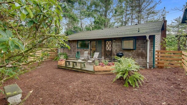 A rustic cabin with a deck, outdoor seating, and a garden area. - D & D Retreat - Quiet Neighborhood! (Cannon Beach)