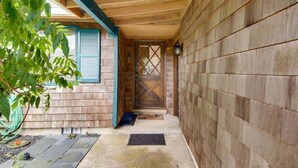 A wooden exterior with a blue door and a small porch area. - D & D Retreat - Quiet Neighborhood! (Cannon Beach)