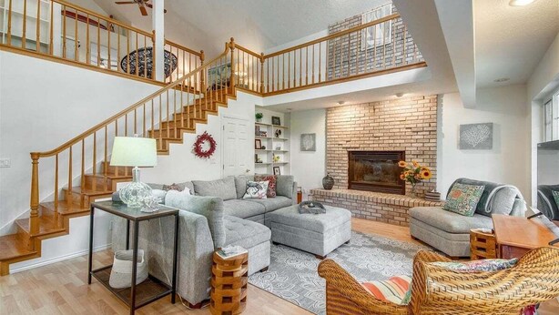 Ein geräumiges Wohnzimmer mit Treppe, Kamin und Balkon.