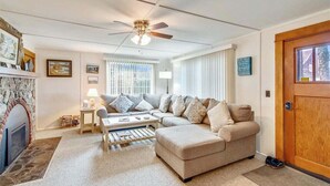 A living room with a fireplace, a sofa, a coffee table, and a ceiling fan. - The Walter House - Quiet Neighborhood! (Cannon Beach)