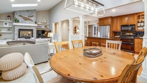 A modern kitchen with wooden cabinets, a built-in microwave, and a large island with seating.