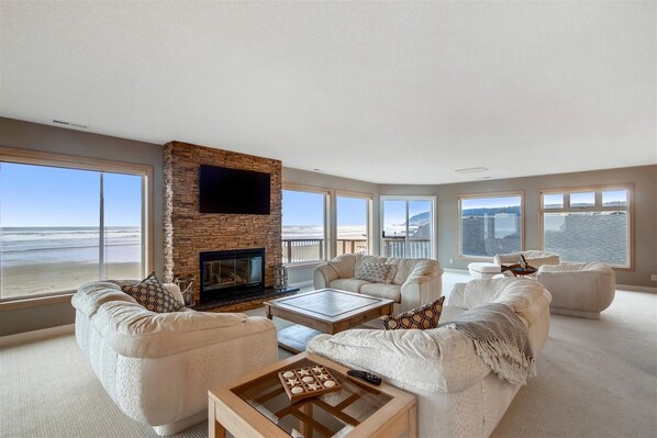 Relax in this cozy living space with a fireplace and ocean views.