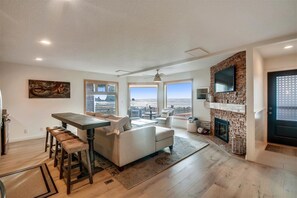 Relax in this spacious living area with a fireplace, flat-screen TV, and stunning beach views.