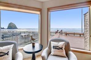 Relax in comfort with a view of the beach and ocean from this room's large windows.
