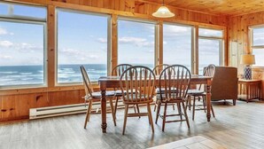 A wooden interior with large windows overlooking the ocean.