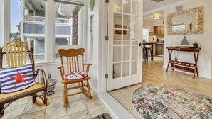 A cozy entryway with a wooden bench, a rocking chair, and a patterned rug. - Sandy Owl - Close Beach Access! (Cannon Beach)