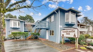 A two-story building with a sign reading "Sandcastle Inn." - Sandcastle Inn #601 - Downtown Apartment! (Cannon Beach)