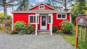 Eine rote Holzhütte mit einem Schild, auf dem "Clark's Cabin" steht, und einem Willkommensschild.