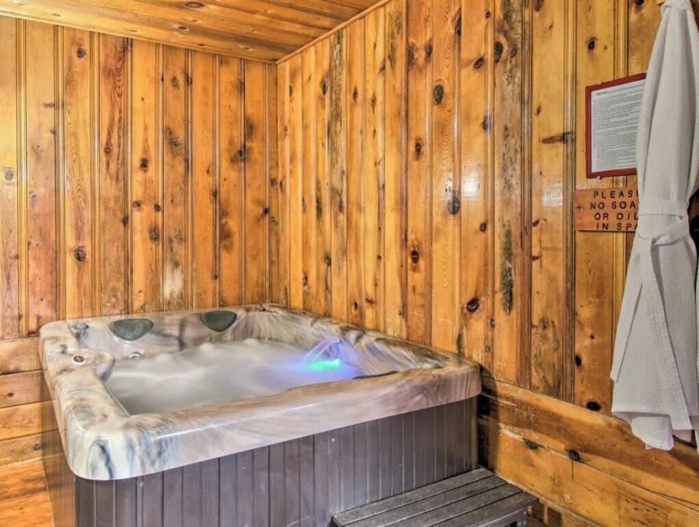 Una cabaña de madera con un jacuzzi y un cartel que prohíbe el uso de jabón o aceites en el spa.