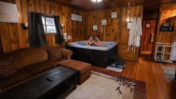 Un interior de madera con una bañera de hidromasaje, un sofá y una mesita de centro.