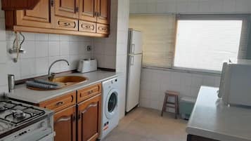 Een koelkast, een microgolfoven, een kookplaat, een waterkoker